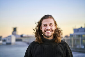 Portrait of bearded young man smiling - FMKF05347