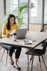 Young businesswoman working at desk in loft office - GIOF05221