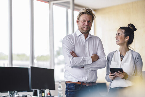 Porträt eines Unternehmers und seiner Assistentin im Büro stehend - RIBF00785