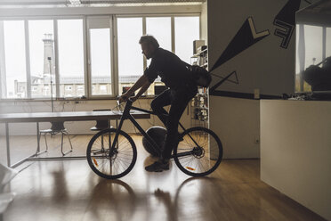 Mann betritt Büro mit seinem Fahrrad - RIBF00819