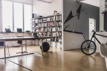 Modernes Kreativbüro mit Gymnastikball und Fahrrad - RIBF00821