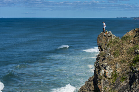 Australien, Queensland, Byron Bay, Mann steht auf einem Felsen, Klippe am Cape Byron, lizenzfreies Stockfoto