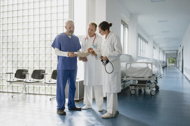 Ärzte besprechen Krankenakte auf dem Krankenhausflur - FSIF03417