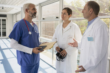 Doctors talking in hospital corridor - FSIF03430