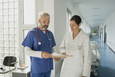 Ärzte besprechen Krankenakte auf dem Krankenhausflur - FSIF03444