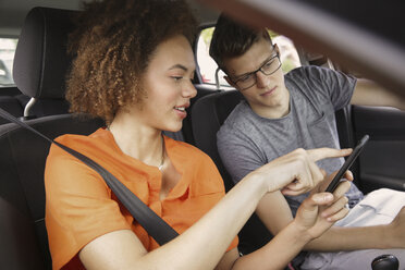 Young couple using smart phone GPS in car - FSIF03445