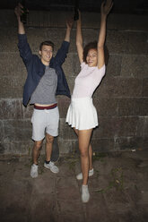 Portrait exuberant young couple drinking beer and cheering - FSIF03485