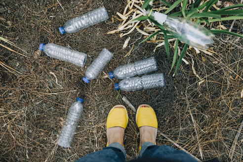 Persönliche Perspektive einer Frau, die vor weggeworfenen Plastikwasserflaschen steht - FSIF03496