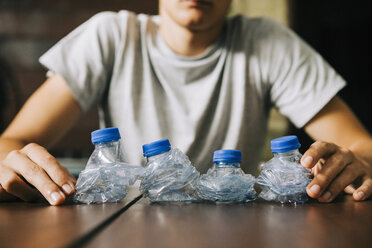 Midsection Of Man Holding Water Bottle While Standing Against Wall stock  photo