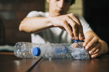 Teenage boy recycling water bottles - FSIF03504