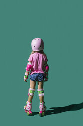 Girl roller skating on green background - FSIF03545
