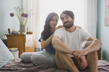 Portrait smiling couple relaxing on bed - FSIF03563