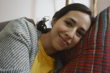 Porträt einer lächelnden Frau, die sich entspannt und auf einem Kissen liegt - FSIF03577