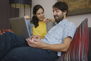 Couple using laptop on living room sofa - FSIF03583