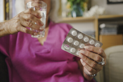 Ältere Frau nimmt Medikamente ein, lizenzfreies Stockfoto