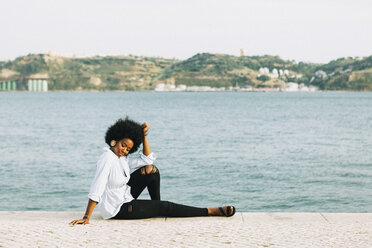 Junge Frau entspannt sich am Ufer des Tejo, Belem, Lissabon, Portugal - FSIF03615