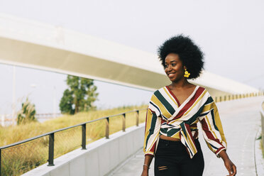 Smiling young woman walking - FSIF03618