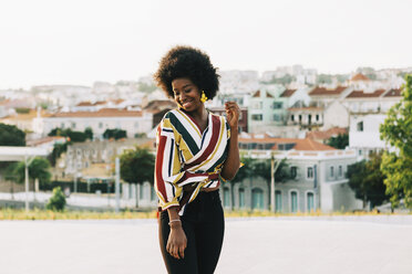 Lächelnde junge Frau auf einer sonnigen Straße, Belem, Lissabon, Portugal - FSIF03627