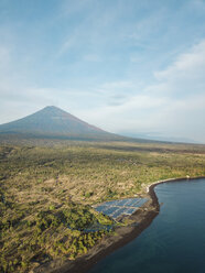 Indonesien, Bali, Amed, Luftaufnahme einer Garnelenfarm und Vulkan Agung im Hintergrund - KNTF02557