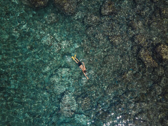 Indonesien, Bali, Mann schwimmt im Meer am Strand von Amed - KNTF02586