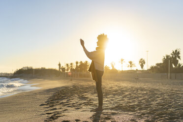 Woman standing on the beach, taking pictures with her smartphone - AFVF02132