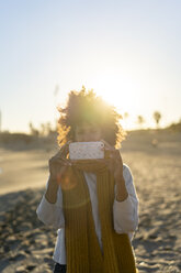 Woman with yellow scarf, using smartphone on the beach - AFVF02133