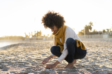 Woman collecting seashells on the beach - AFVF02143