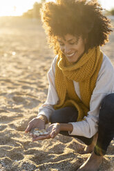 Frau sammelt Muscheln am Strand - AFVF02146