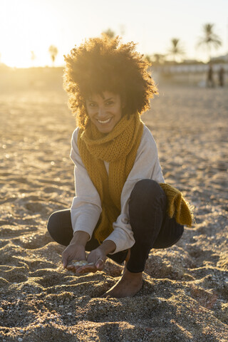 Frau sammelt Muscheln am Strand, lizenzfreies Stockfoto