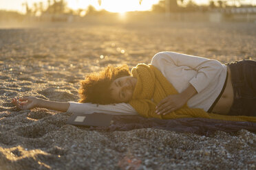 Woman lying in the sand, relaxing on the beach - AFVF02152