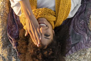 Woman lying in the sand, relaxing on the beach, covering one eye - AFVF02160