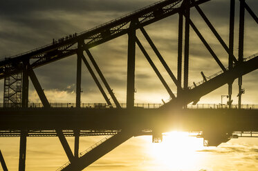 Australia, Sydney, Tourists climbing Sydney harbour bridge at sunset - RUNF00430