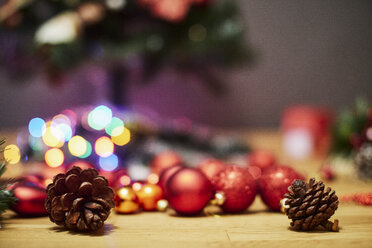 Tannenzapfen und Weihnachtskugeln auf Holzboden - BZF00474