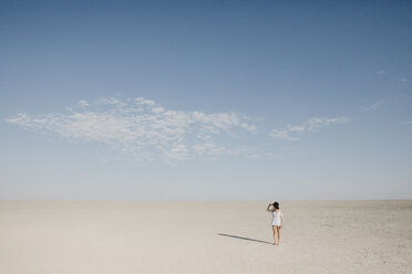 Woman with black hat, walking in the desert - LHPF00206