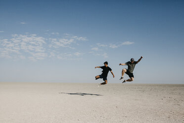 Zwei junge Männer springen in die Wüste - LHPF00210