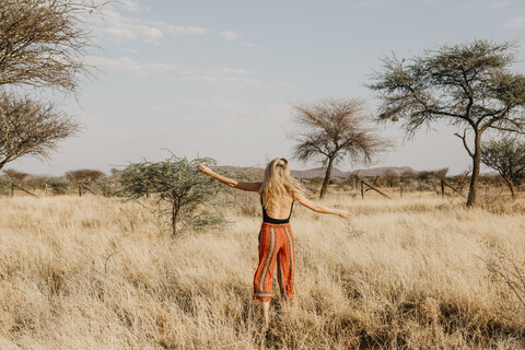 Afrika, Namibia, blonde Frau im Grasland, lizenzfreies Stockfoto