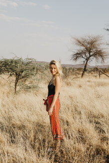 Afrika, Namibia, blonde Frau im Grasland - LHPF00226