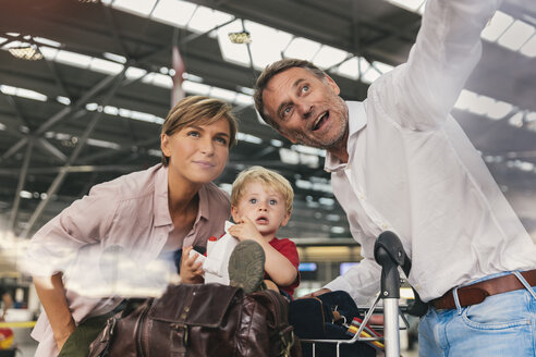 Happy family with baggage cart at the airport - MFF04719