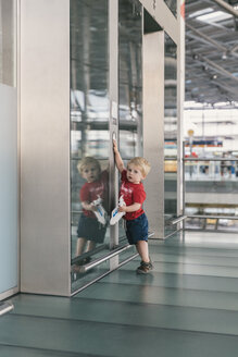 Kleiner Junge drückt den Aufzugsknopf am Flughafen - MFF04726