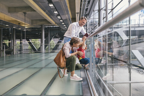 Glückliche Familie am Flughafen mit Blick aus dem Fenster, lizenzfreies Stockfoto