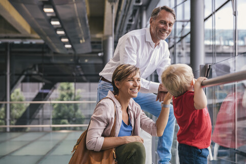 Glückliche Familie am Flughafen mit Blick aus dem Fenster, lizenzfreies Stockfoto