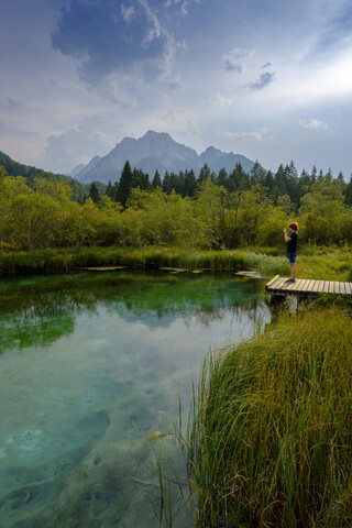 Slowenien, Gorenjska, bei Ratece, Sava Dolinka, Quelle, Zelenci-See, junger Mann steht auf Steg, lizenzfreies Stockfoto
