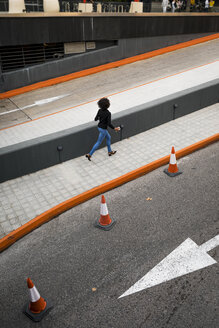 Rückenansicht einer Geschäftsfrau, die auf dem Bürgersteig läuft - MAUF02009