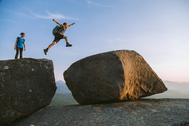 Man jumping across boulders, Pitchoff Mountain, Adirondack Mountains, New York State, USA - AURF07950