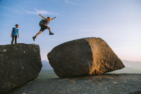 Mann springt über Felsbrocken, Pitchoff Mountain, Adirondack Mountains, New York State, USA - AURF07950