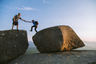 Mann hilft Frau über Felsbrocken, Pitchoff Mountain, Adirondack Mountains, New York State, USA - AURF07951