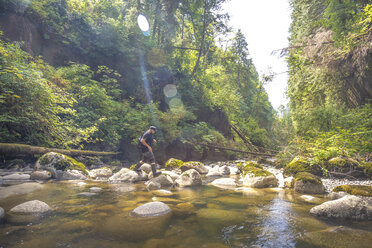 Mann überquert Bach im Kanaka Creek Regional Park, Maple Ridge, British Columbia, Kanada - AURF07968