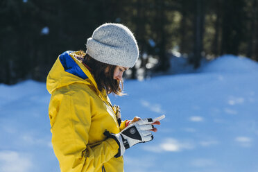 Frau telefoniert im Freien im Winter, Whistler, British Columbia, Kanada - AURF08075