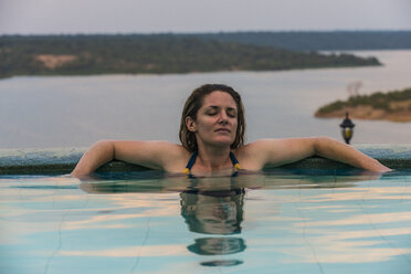 Afrika, Uganda, Queen Elizabeth National Park, Frau entspannt sich in einem Pool oberhalb des Kazinga-Kanals - RUNF00510