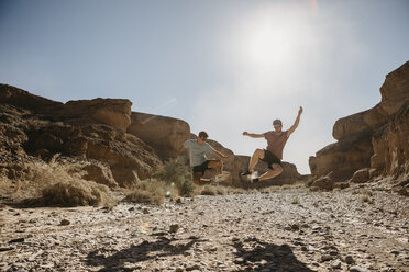 Namibia, Namib-Wüste, Namib-Naukluft-Nationalpark, Sossusvlei, zwei Männer springen in den Sesriem Canyon - LHPF00230